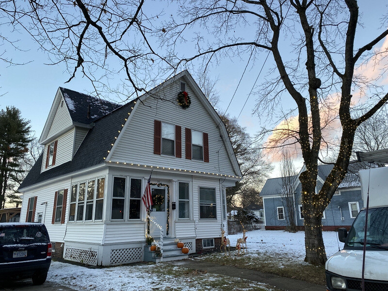 Suburban New Hampshire home in daylight before permanent lighting
