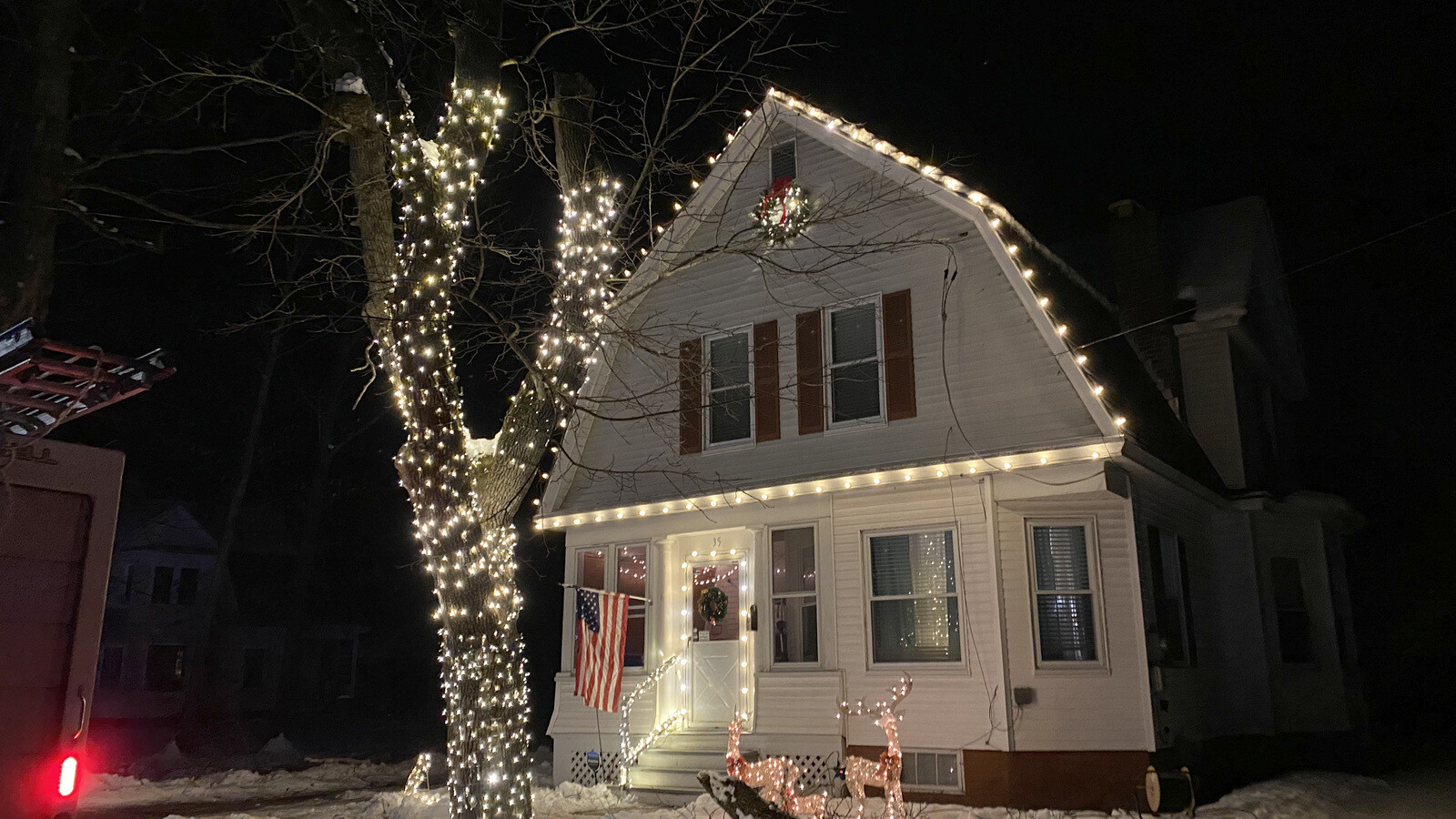 A home and street beautifully lit for Christmas at night